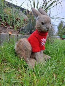movable teddy-style toy rabbit in a red sweater